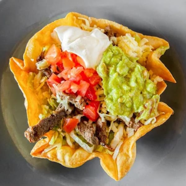 Pueblo Viejo Mexican Restaurant's taco salad in a crispy shell with meat, lettuce, tomatoes, guacamole, and sour cream.