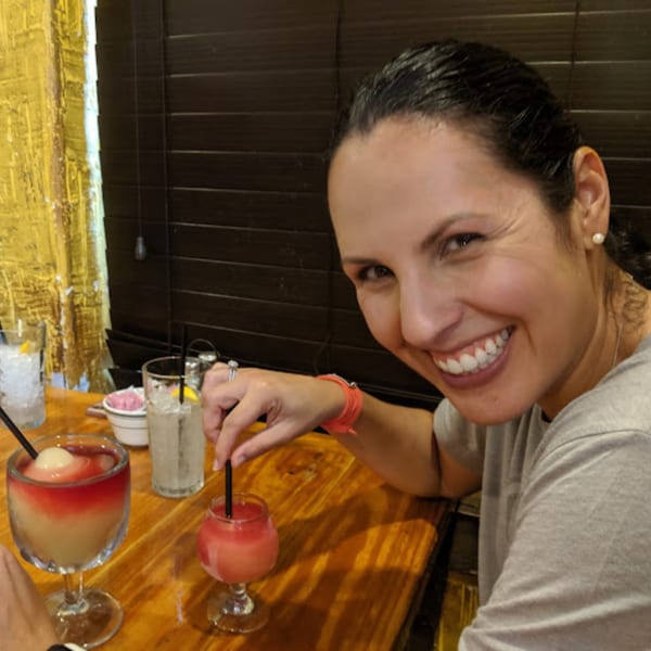 Smiling woman enjoying a colorful frozen drink at Pueblo Viejo Mexican Restaurant.
